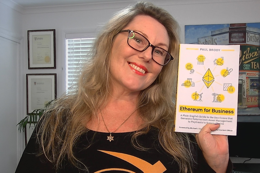 Image of Electra Frost holding a book titled Ethereum for Business