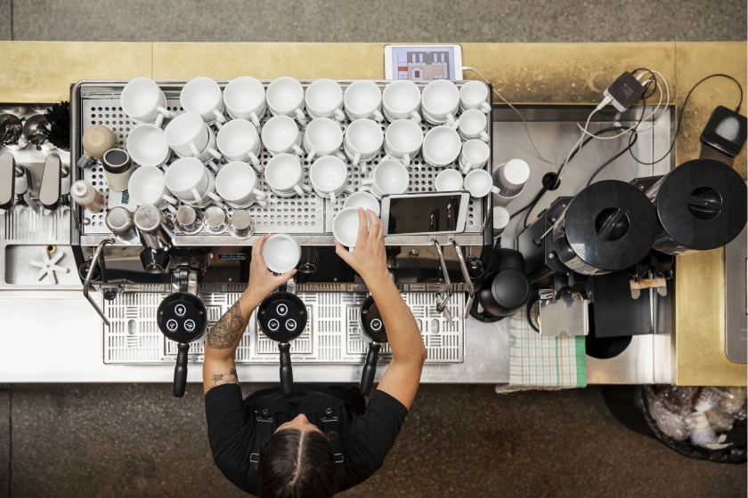 overhead shot of person arranging coffee cups in a coffee house