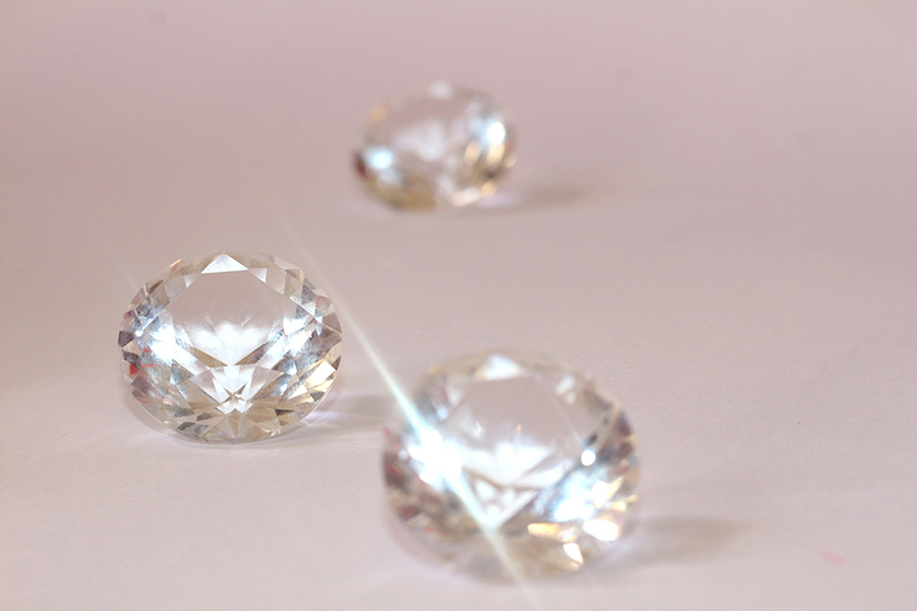 Loose diamonds on a pink background.