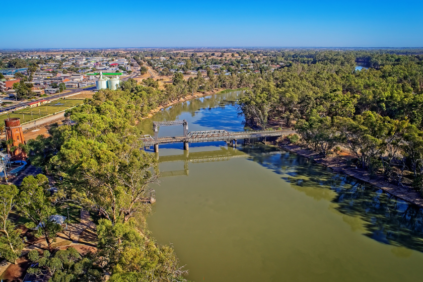 Bird's eye view of the Murray River with surrounding bushland and the city of Swan Hill to the left of the river bank