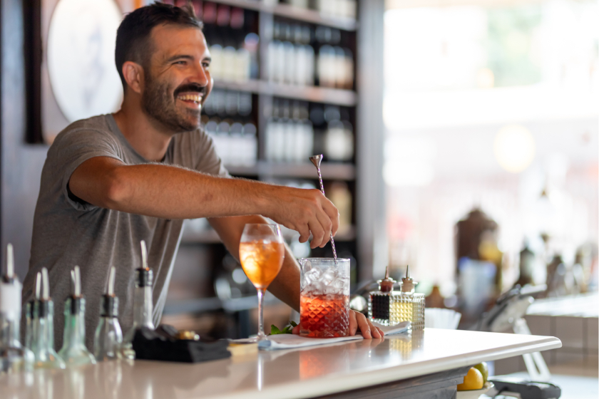 smiling bartender making a cocktail 